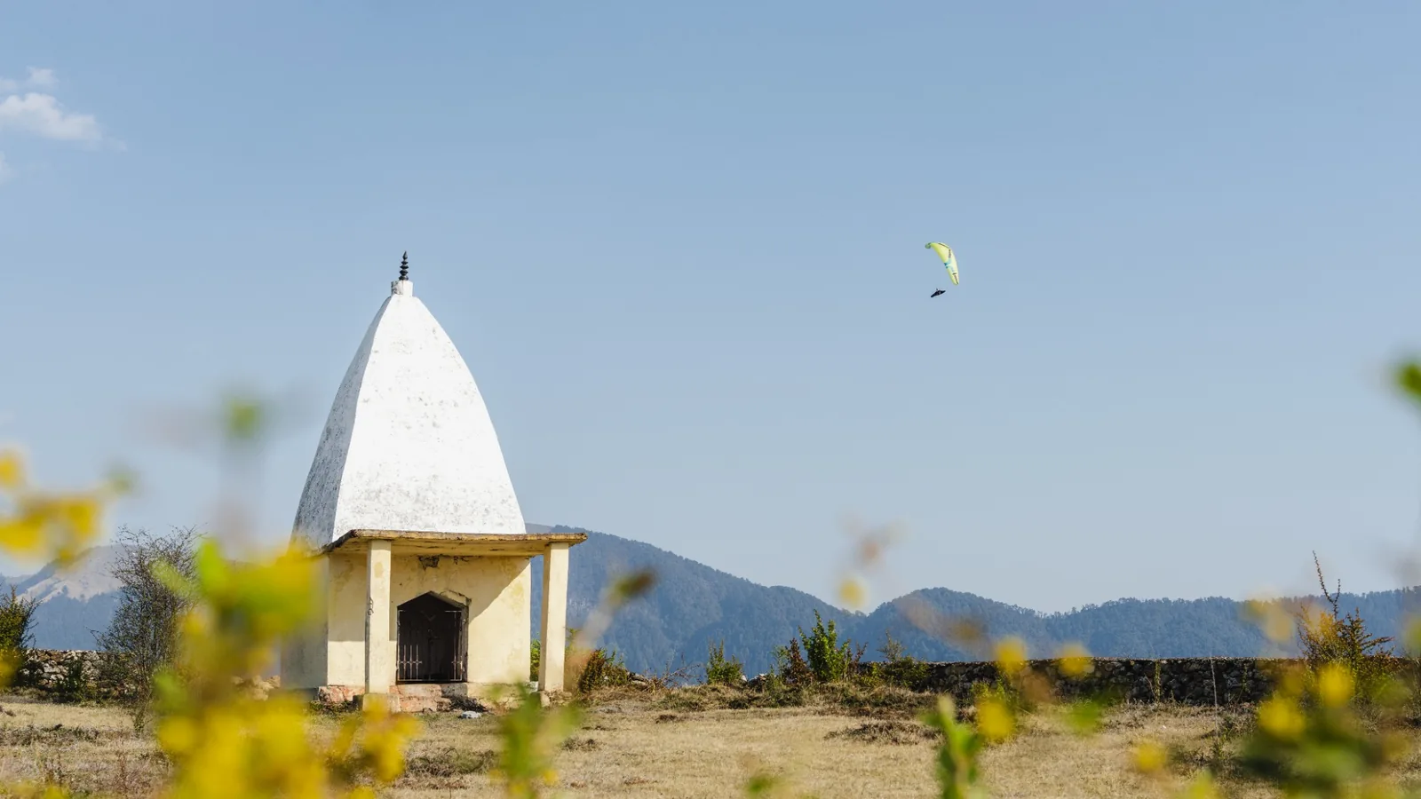 Paraglider launching with Himalayan mountains behind