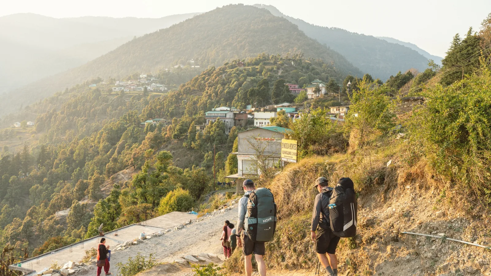 Expedition team hiking through a mountain village in northern India